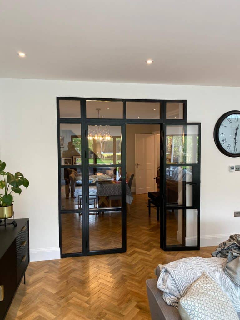 steel look aluminium doors separating a living and kitchen in a house